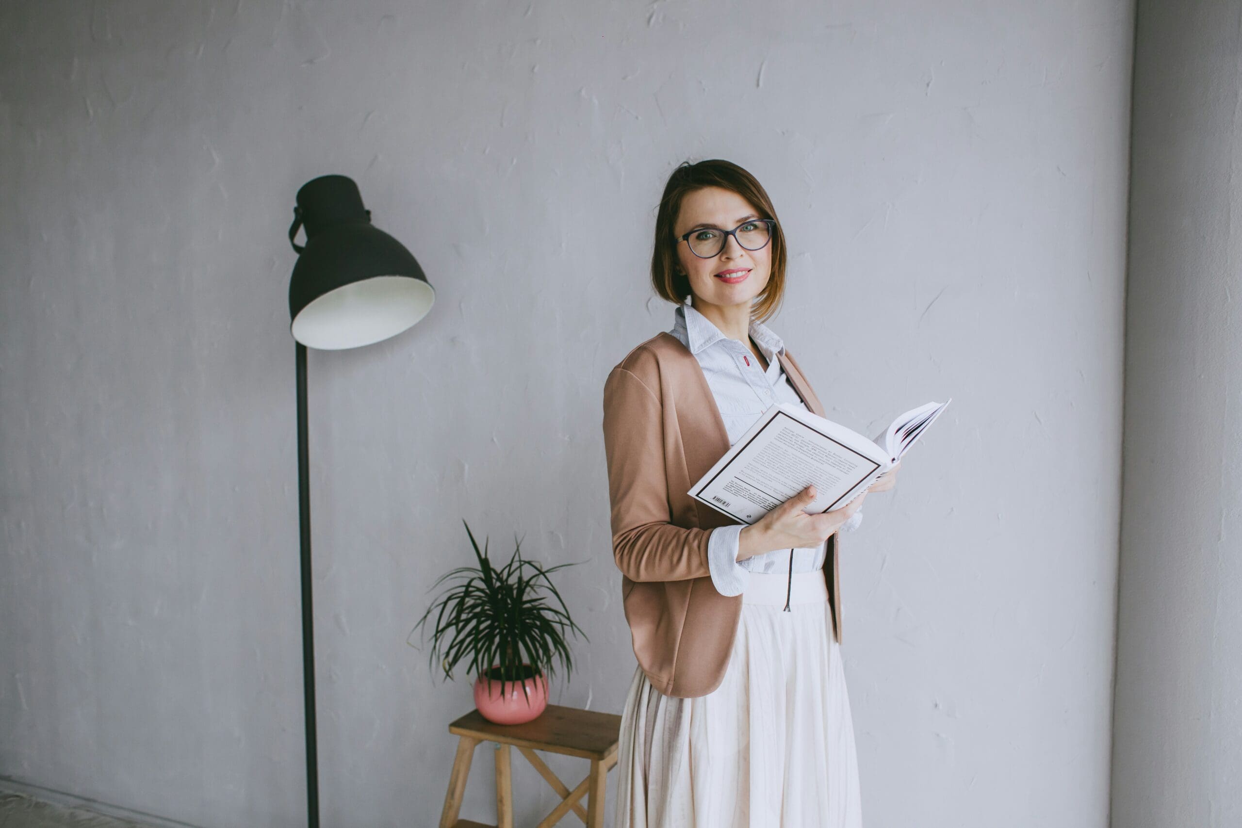 Woman therapist standing and holding a book.